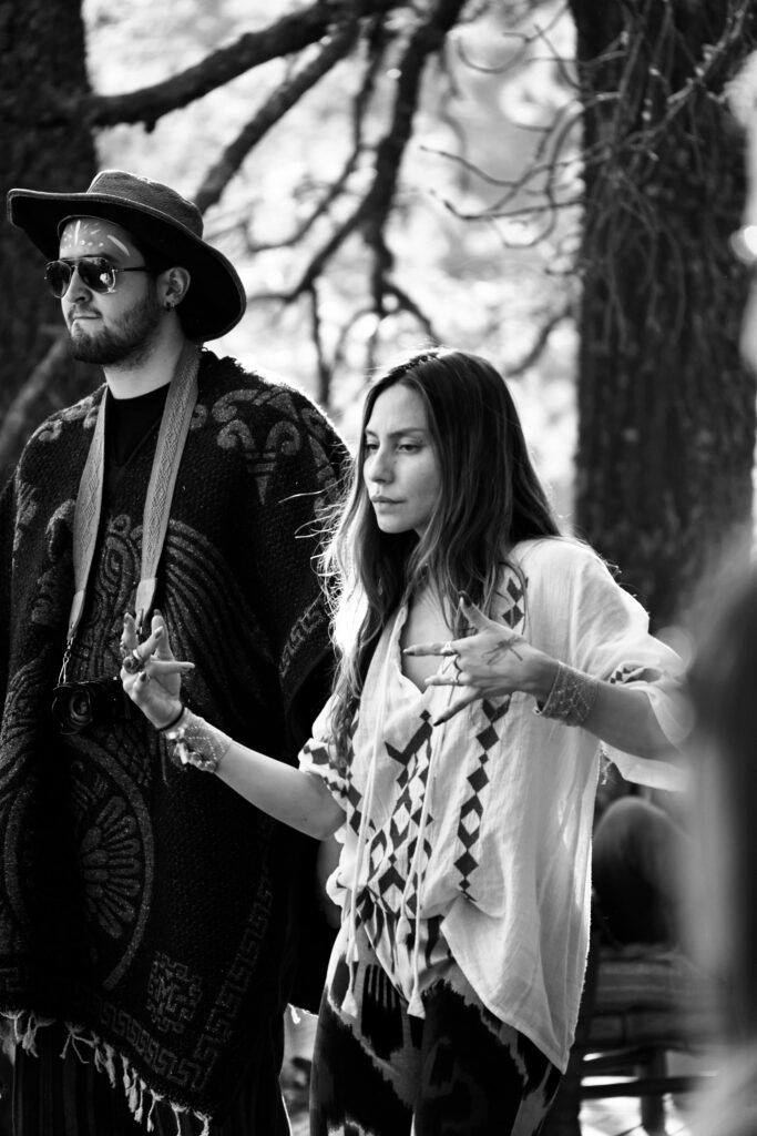 A stylish couple in bohemian attire captured in black and white outdoors.