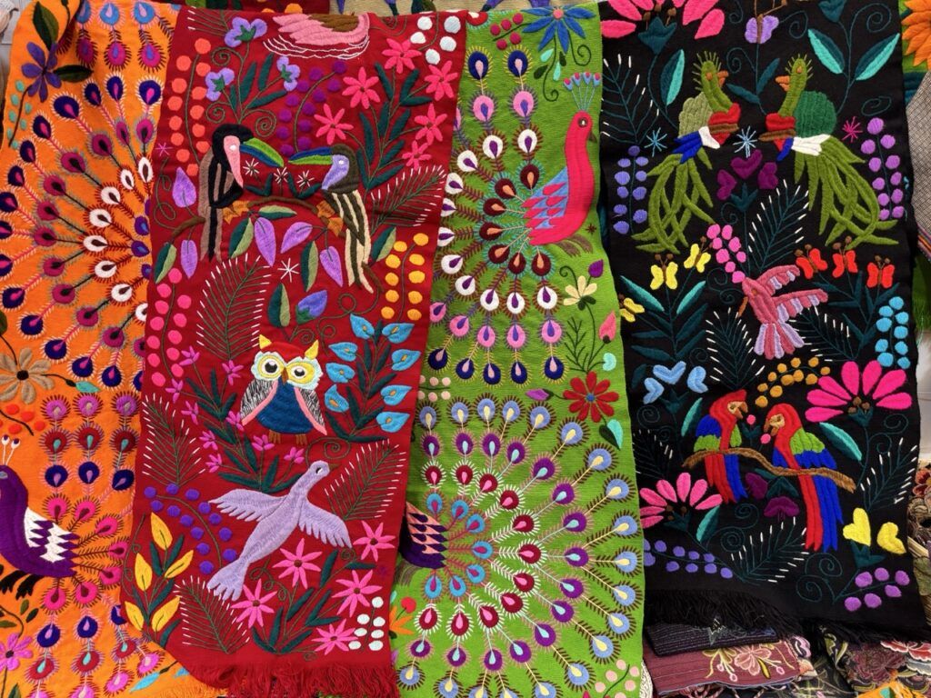 wielobarwne, bogate w motywy fantazyjnych ptaków i kwiatów tkaniny